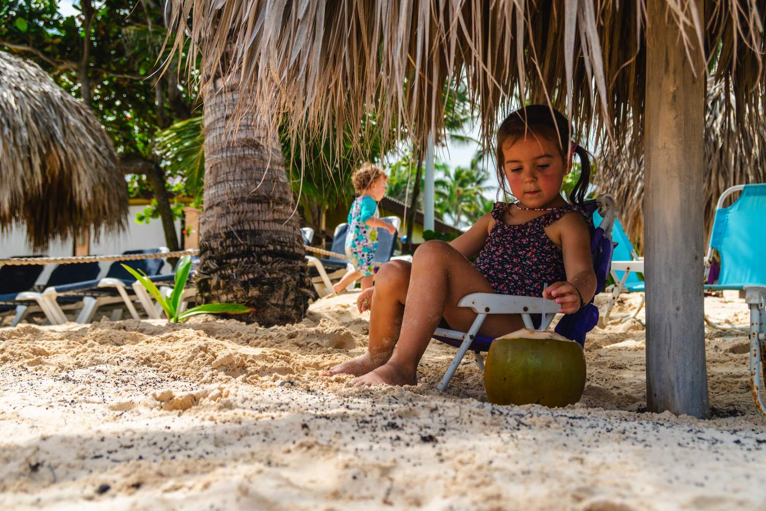 Kid drinking coconut juice on a beach in Dominican Republic