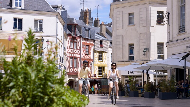 Couple circulant à vélo sur la place du Martroi, à Orléans - Crédit photo : Les Coflocs - CRT Centre-Val de Loire